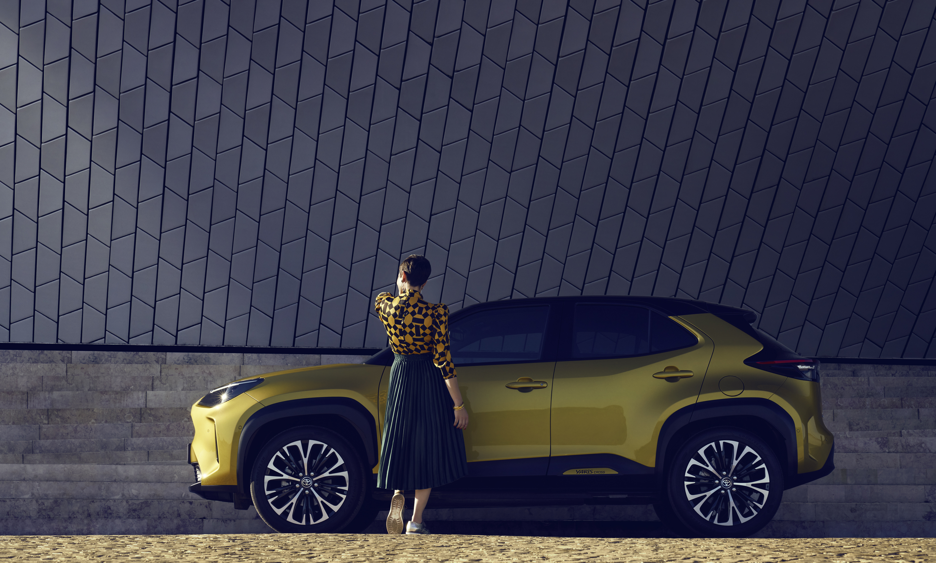 Toyota-Yaris-cross-exterieur-geel-zijkant-vrouw