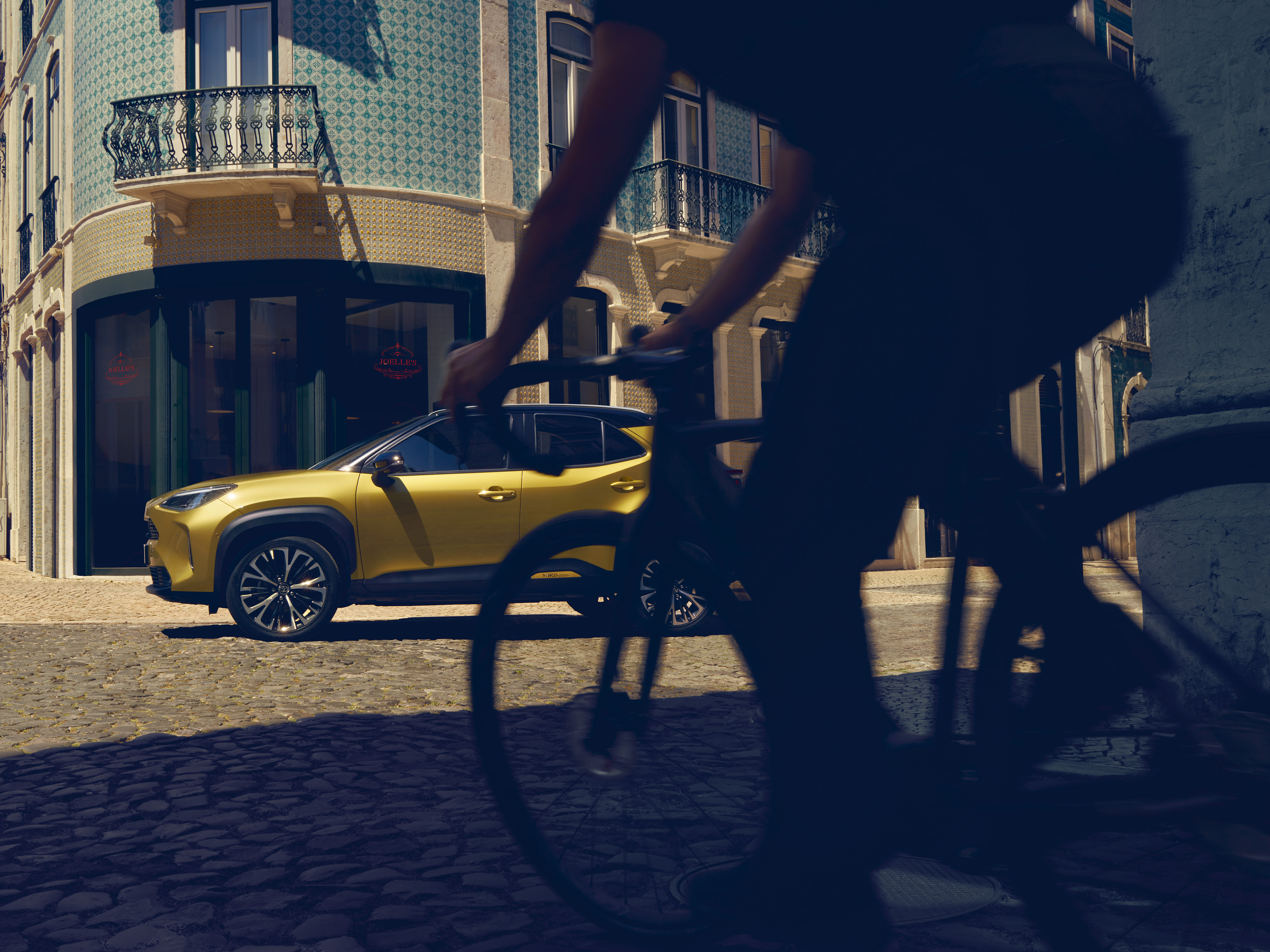 Toyota-Yaris-Cross-exterieur-zijkant-geel-straat-fiets
