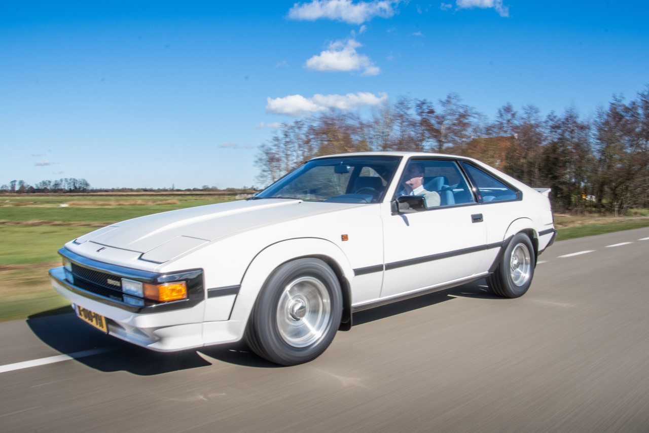 Toyota Celica Supra, exterieur, wit, linksvoor, rijdend langs boerderij