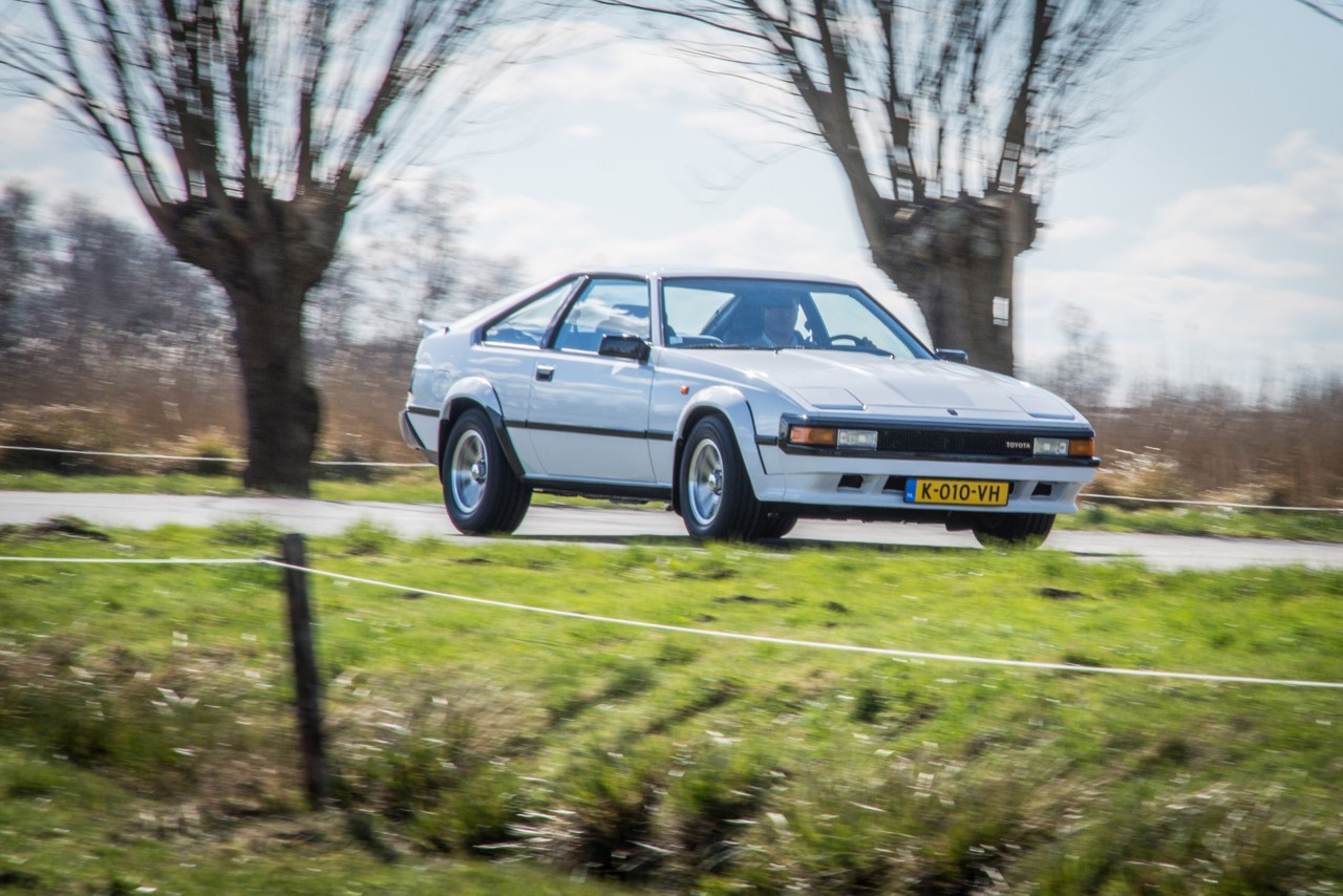 Toyota Celica Supra, exterieur, wit, rechtsvoor, rijdend langs wilgenbomen