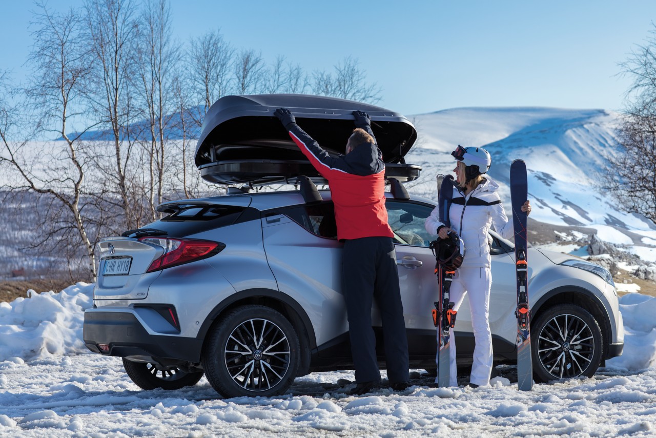 Mensen die ski's op auto laden