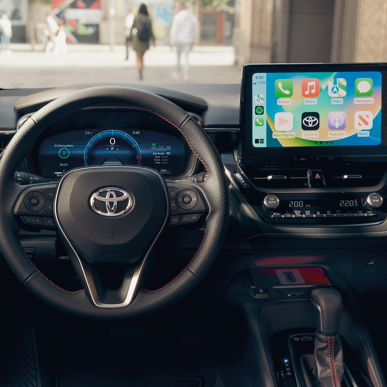 Een multimedia touch-screen toont het startscherm van Apple CarPlay, in een Toyota met een zwart dashboard.