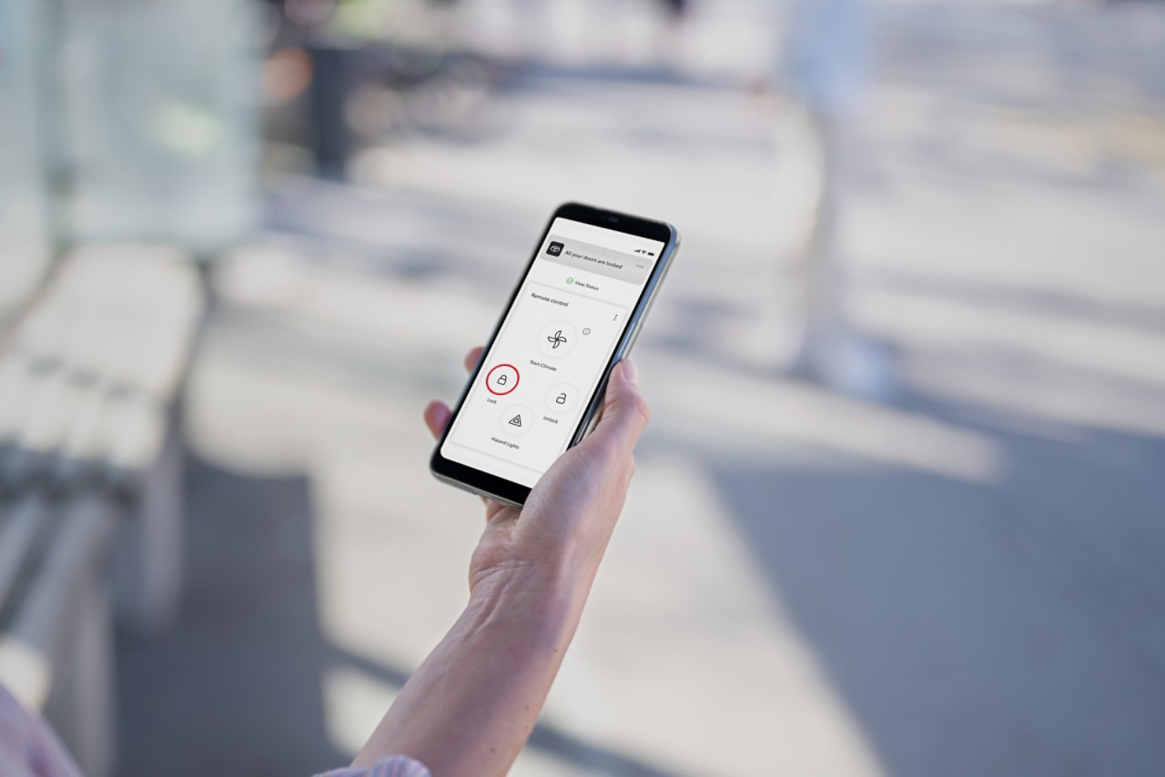 Een smartphone ligt naast de versnellingspook van een Tyota. Zichtbaar is de Usage-Based Insurance functie van de TOYOTA MyT app.
