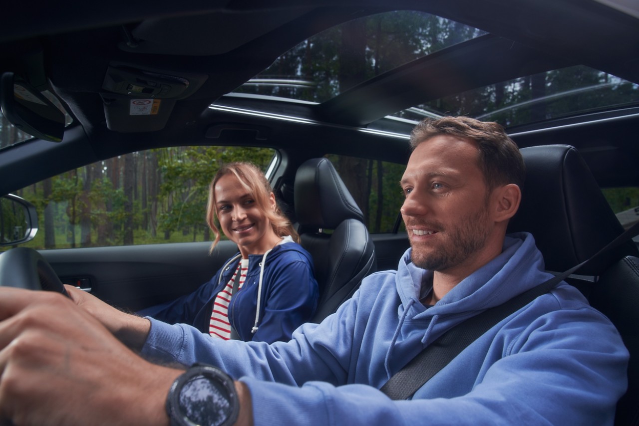Man en vrouw rijden in Toyota Corolla Cross